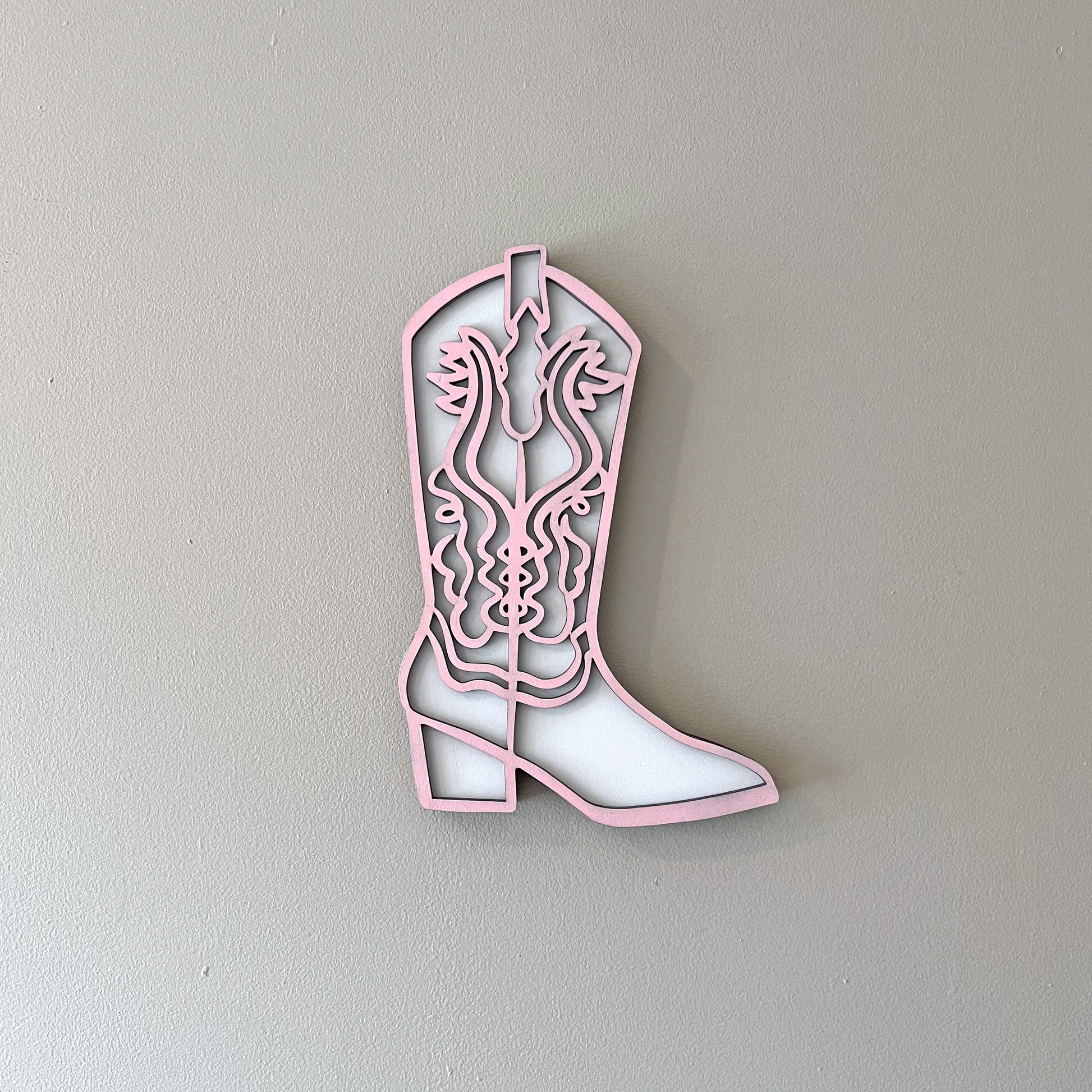 Pink and white cowgirl boot wall decor.